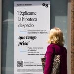 Una mujer ante un cartel bancario sobre las hipotecas.