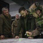 Ukrainian President Volodymyr Zelenskyy, Commander of Ukraine's Ground Forces Col.-Gen. Oleksandr Syrsky, right, and Roman Mashovets, deputy head of the Presidential Office, look at a map during their visit to the front-line city of Kupiansk, Kharkiv region, Ukraine, Thursday, Nov. 30, 2023.