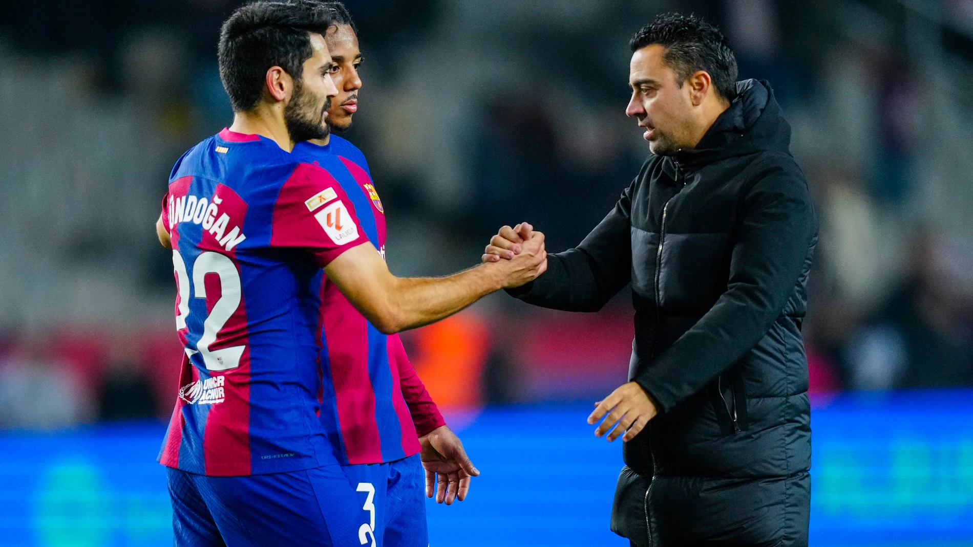 BARCELONA, 03/12/2023. El entrenador del Barcelona, Xavi Hernández (d) saluda a sus jugadores Koundé (2i) y Gündogan (i) al término del partido correspondiente a la jornada 15 de LaLiga que disputan FC Barcelona y Atlético de Madrid este domingo en el Estadio Olímpico de Barcelona.- EFE/ Enric Fontcuberta