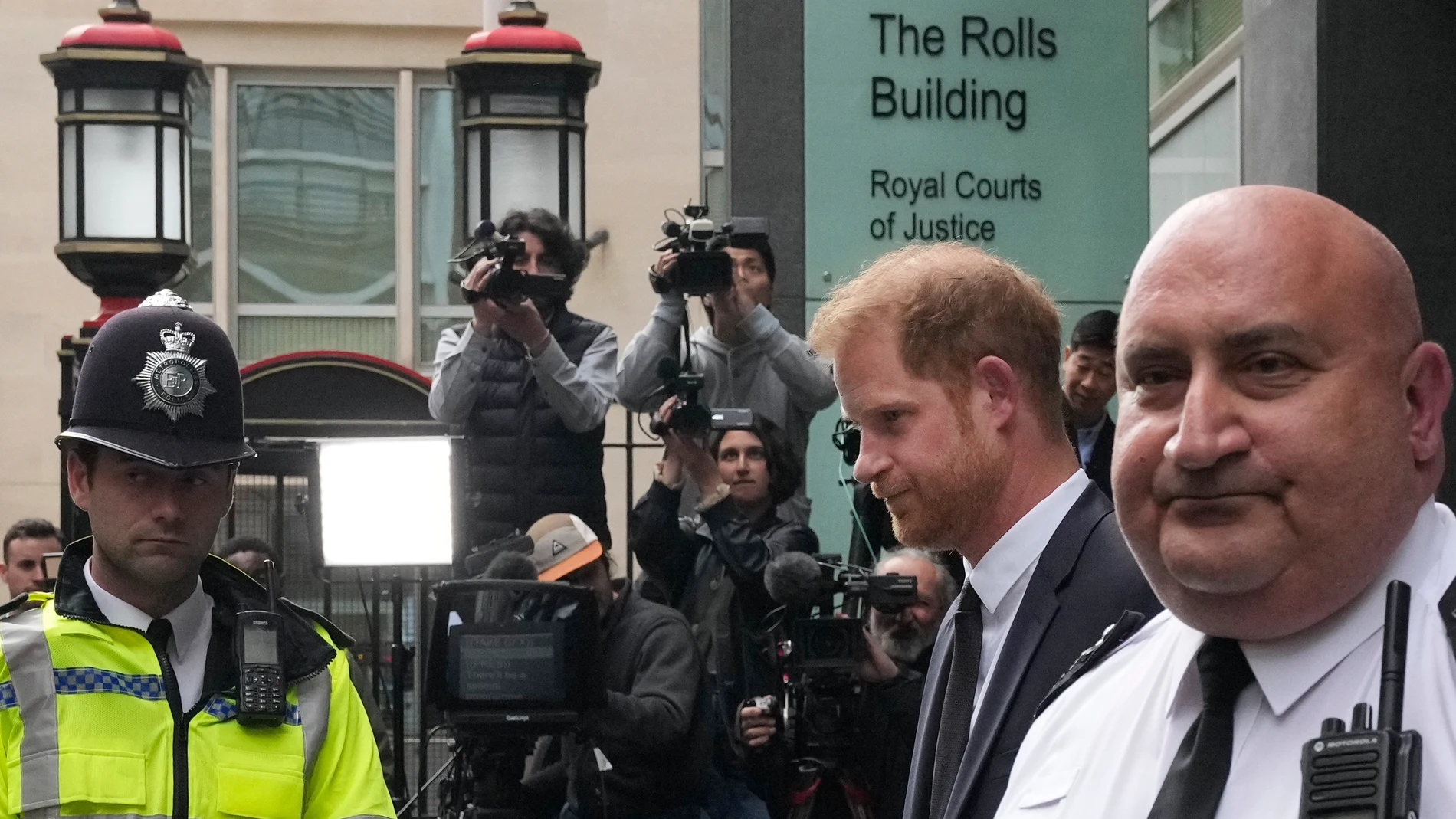 FILE - Prince Harry, second from right, escorted by security leaves the High Court after giving evidence in London, Tuesday, June 6, 2023. Prince Harry is challenging on Tuesday, Dec. 5, 2023, the British government’s decision to strip him of his security detail after he gave up his status as a working member of the royal family and moved to the United States. The Duke of Sussex said he wants protection when he visits home and claimed it's partly because an aggressive press jeopardizes his sa...