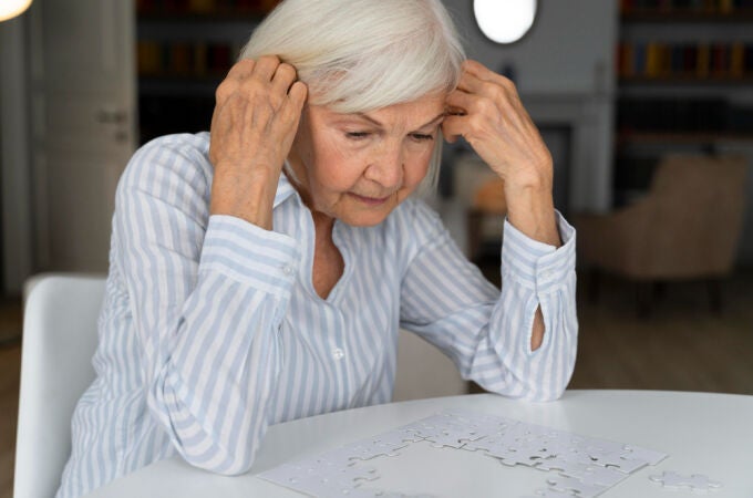 Una mujer anciana hace un puzle
