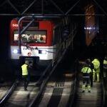 Varios operarios junto al tren de Cercanías que ha descarrilado este martes pasadas las dos y media de la tarde en la entrada de la madrileña estación de Atocha, lo que ha interrumpido el servicio entre dicha estación y Recoletos, en un momento de fuerte afluencia por el puente de la Constitución.