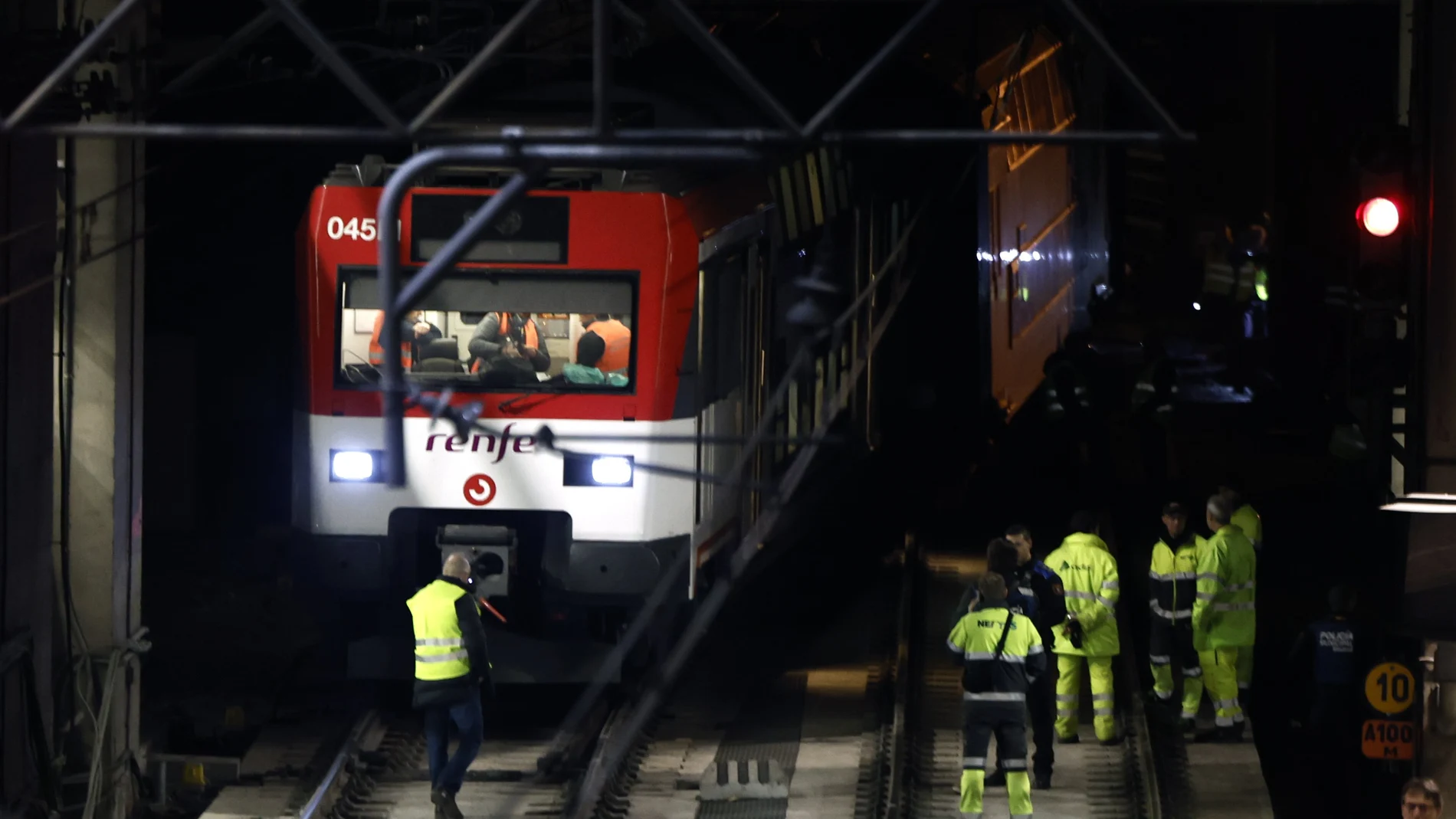 Varios operarios junto al tren de Cercanías que ha descarrilado este martes pasadas las dos y media de la tarde en la entrada de la madrileña estación de Atocha, lo que ha interrumpido el servicio entre dicha estación y Recoletos, en un momento de fuerte afluencia por el puente de la Constitución.