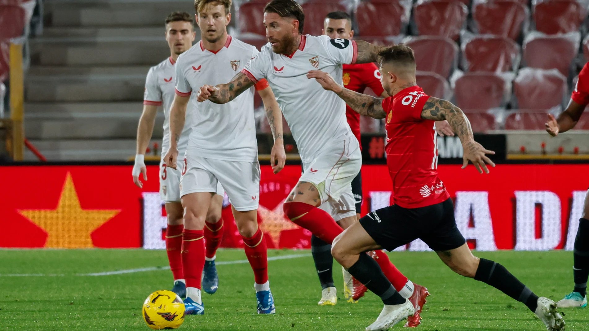 PALMA DE MALLORCA, 09/12/2023.- El defensa del Sevilla, Sergio Ramos (c), conduce el balón ante el defensa del Mallorca, Pablo Maffeo, durante el encuentro correspondiente a la jornada 16 de primera división que Mallorca y Sevilla disputan hoy sábado en el estadio de Son Moix, en la capital balear. EFE/CATI CLADERA.