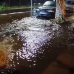 Agua saliendo en la calle Betis, en Lora del Río, tras reventar la tubería que la atraviesa. vAYUNTAMIENTO DE LORA DEL RIO