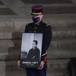 Un guardia republicano muestra un retratato del profesor asesinado Samuel Paty