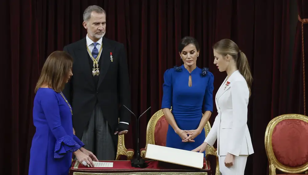 La princesa Leonor (d) jura la Constitución ante la presidenta del Congreso, Francina Armengol (i), y los reyes de España, Felipe VI y Letizia, en el día de su 18 cumpleaños, este martes en el Congreso de los Diputados, en una ceremonia que representa el hito más importante de su trayectoria institucional y pavimenta el camino para que algún día se convierta en reina.