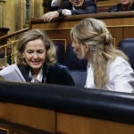 La vicepresidenta segunda y ministra de Trabajo, Yolanda Díaz, conversa con la vicepresidenta primera del Gobierno y ministra de Economía, Nadia Calviño, al inicio de la primera sesión de control al nuevo Gobierno celebrada en el Congreso. 