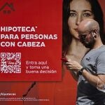Una oficina de un banco con publicidad de hipotecas en su fachada.