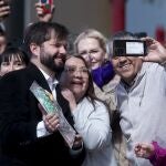 Chile's President Gabriel Boric, left, poses for a picture with supporters as he arrives to vote on the draft of a new constitution in Punta Arenas, Chile.