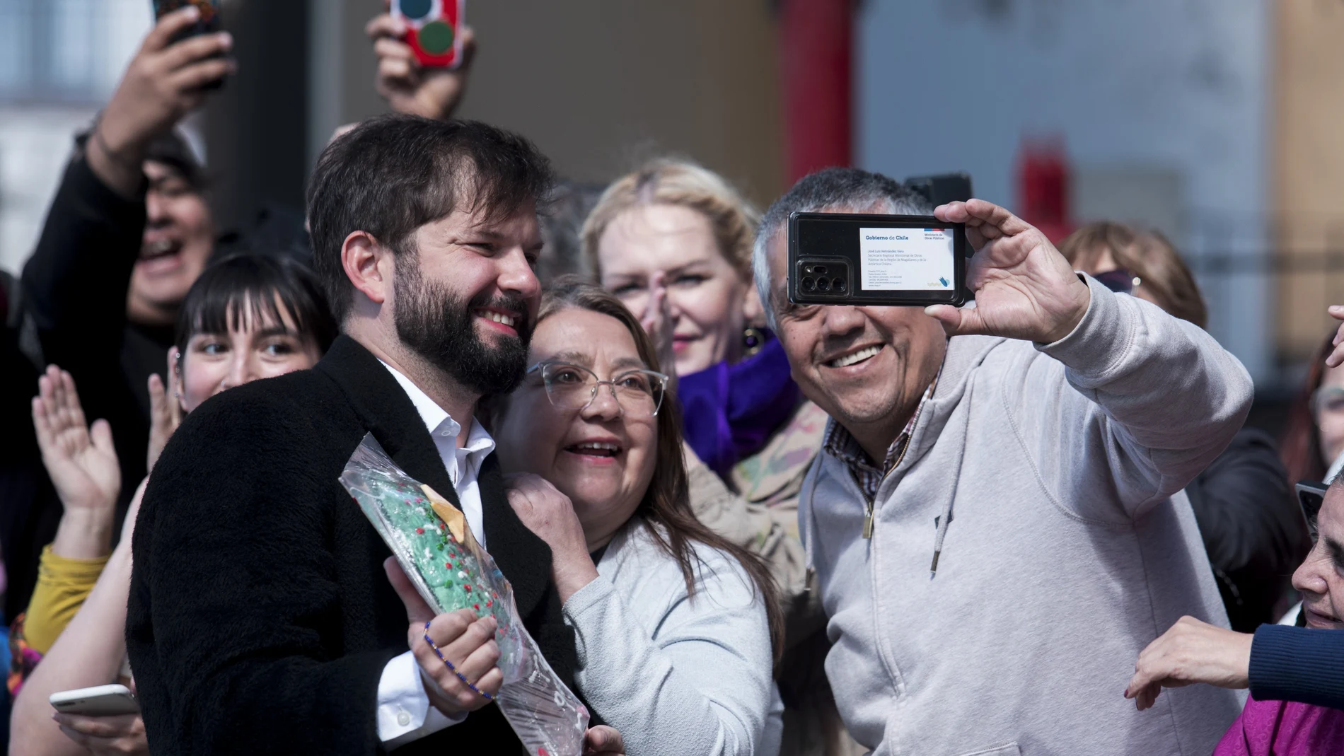 Chile's President Gabriel Boric, left, poses for a picture with supporters as he arrives to vote on the draft of a new constitution in Punta Arenas, Chile.