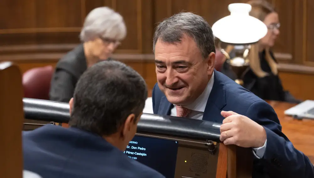 El presidente del Gobierno, Pedro Sánchez (i), conversa con el portavoz del PNV en el Congreso, Aitor Esteban (d), durante un pleno en el Congreso de los Diputados, a 20 de diciembre de 2023, en Madrid (España).