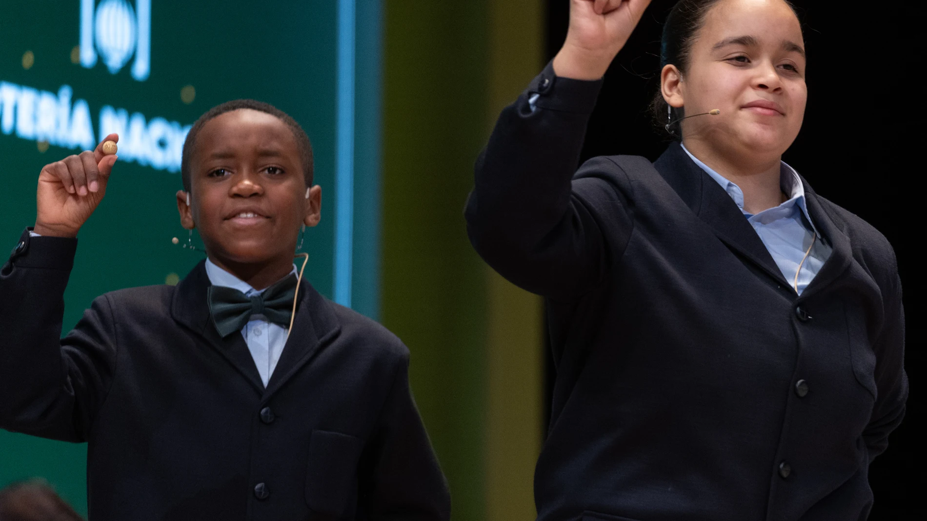 Paula Figuereo Figuereo y Ángel Albaga Elebiyo cantan un quinto premio, el número 86.007, durante el Sorteo Extraordinario de la Lotería de Navidad 2023 en el Teatro Real de Madrid, a 22 de diciembre de 2023, en Madrid (España). El sorteo se celebra en esta ocasión con aforo completo en el patio de butacas del Teatro Real. Hoy se celebra el Sorteo Extraordinario de Navidad 2023, con el que el Estado reparte 2.590 millones de euros en premios entre los 185 millones de décimos de Lotería puesto...