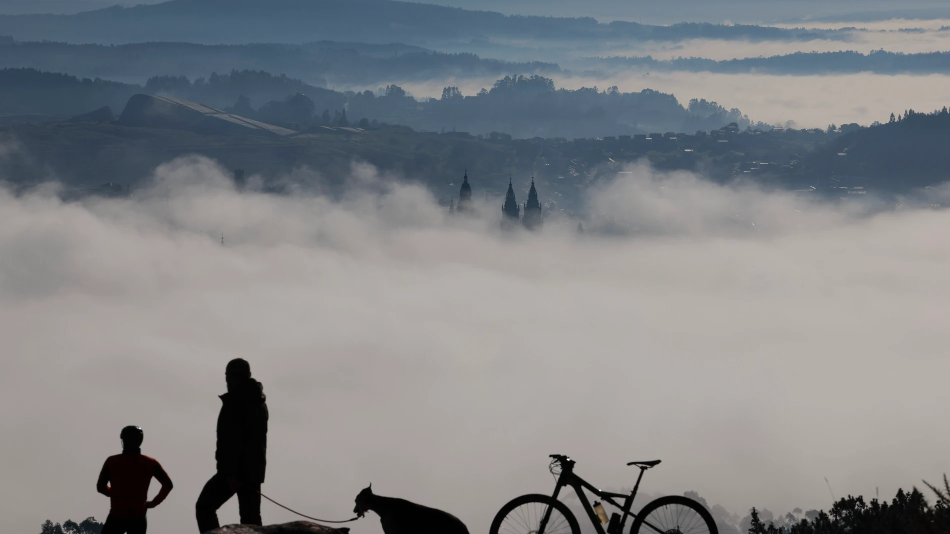 Las torres de la catedral asoman sobre Santiago de Compostela, cubierto de niebla, este lunes. La Agencia Estatal de Meteorología (Aemet) prevé para mañana que continúe una situación anticiclónica invernal, con predominio de cielos poco nubosos o despejados, aunque con nieblas, sobre todo de madrugada, en la meseta norte, Extremadura, oeste de la meseta sur y zonas de la cuenca del Ebro. EFE/ Lavandeira Jr