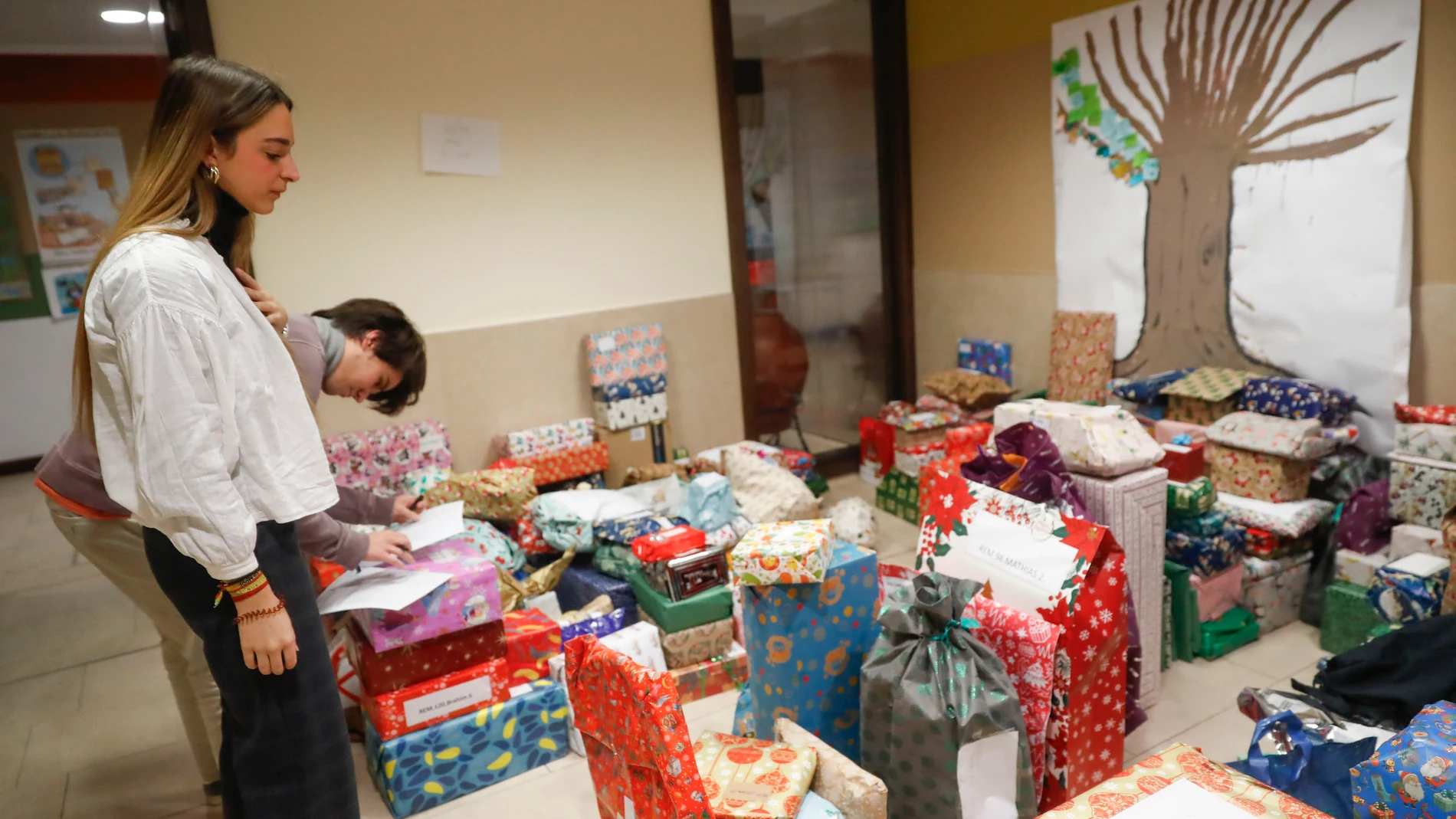 MADRID, 26/12/2023.- Varias voluntarias preparan varios regalos en un centro de Jesuitas en Madrid en el marco del Proyecto Reyes Magos de Verdad, una iniciativa que nació hace años en la capital para hacer regalos a niños y ancianos que viven en centros de acogida y residencias en su mayoría y sin recursos económicos. EFE/J.P.Gandul