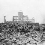 In this Sept. 8, 1945 file photo, an allied correspondent stands in the rubble in front of the shell of a building that once was a movie theater in Hiroshima, Japan, a month after the first atomic bomb ever used in warfare was dropped by the U.S. on Aug. 6, 1945