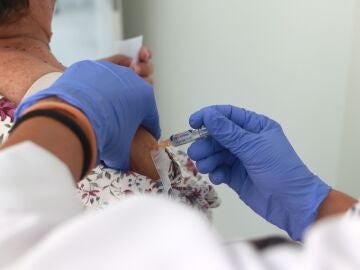 Una mujer se vacuna contra el virus de la gripe