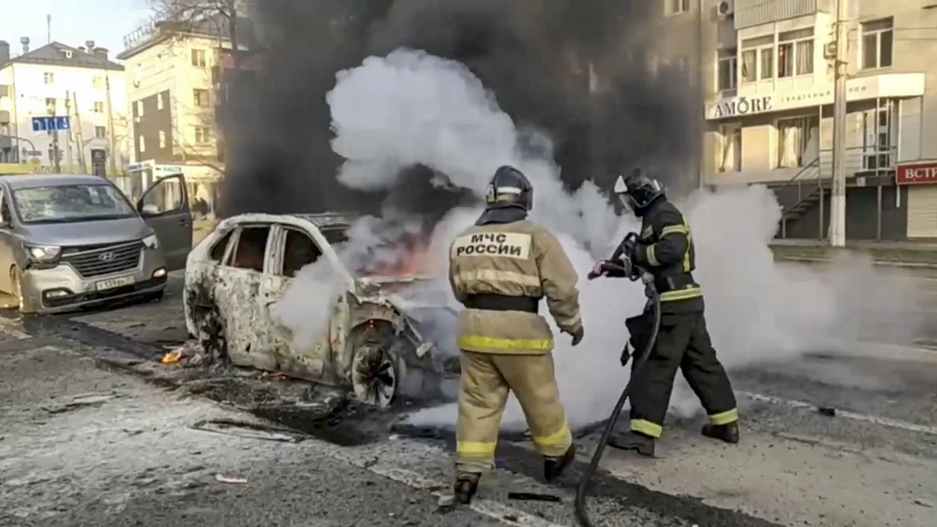 A handout photo made available by the Russian Emergency Ministry press service shows Russian firefighters extinguishing a burning car after shelling in Belgorod, Russia, 30 December 2023. 12 adults and two children were killed due to shelling by the Ukrainian Armed Forces, the press service of the Russian Ministry of Emergency Situations reported 30 December.