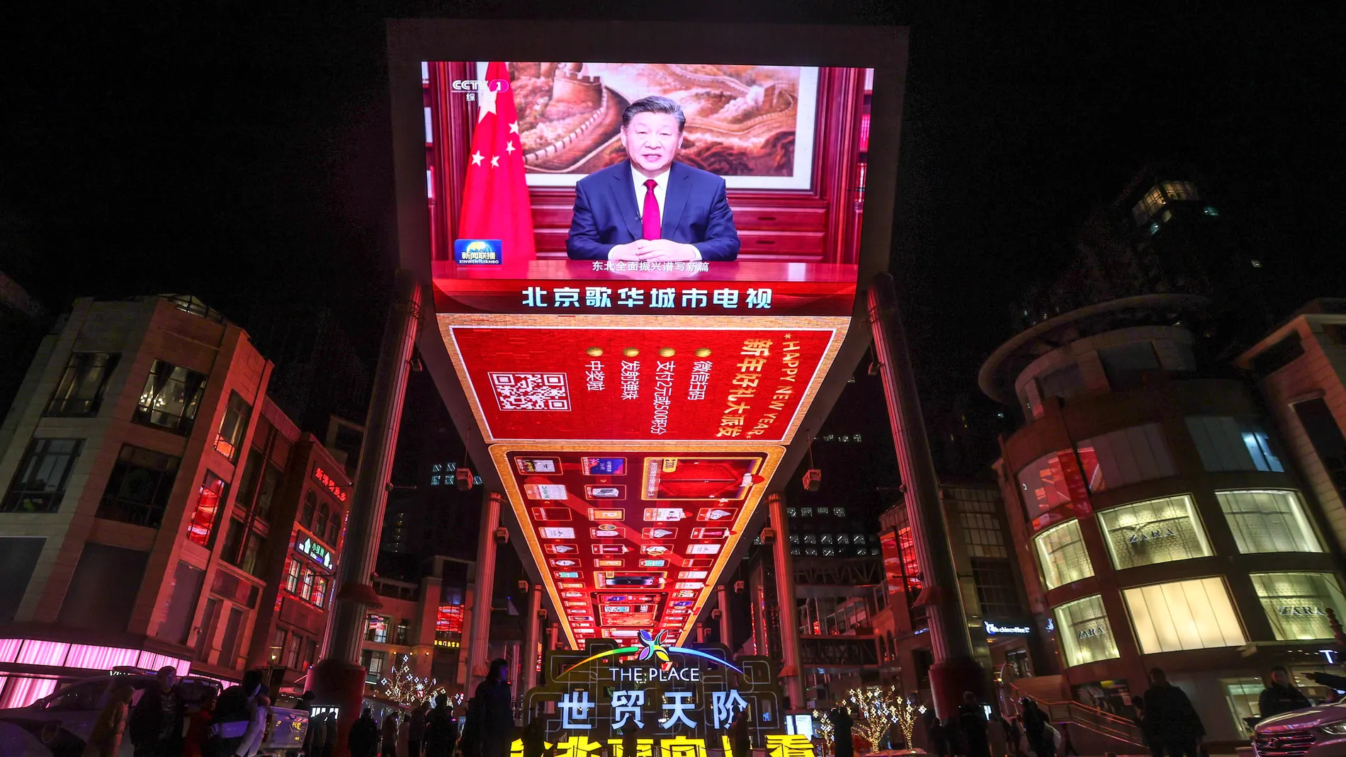 Beijing (China), 31/12/2023.- People walk past a screen that shows Chinese President Xi Jinping delivering a New Year address to ring in 2024, in Beijing, China, 31 December 2023. EFE/EPA/WU HAO