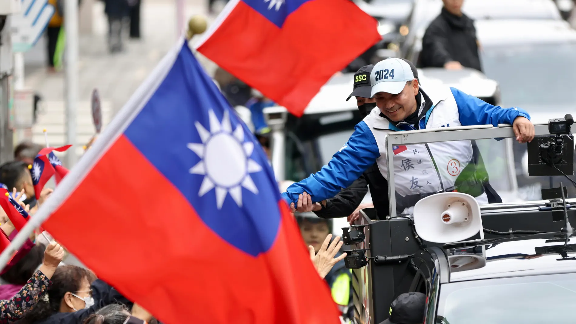 New Taipei City (Taiwan), 04/01/2024.- Kuomintang (KMT) or the Chinese Nationalist Party presidential candidate Hou Yu-ih (R) reacts during a motorcade campaign in New Taipei city, Taiwan, 04 January 2024. The Taiwan presidential election is scheduled to be held on 13 January 2024. (Elecciones) EFE/EPA/RITCHIE B. TONGO