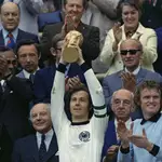 FILE - West Germany captain, Franz Beckenbauer holds up the World Cup trophy after his team defeated the Netherlands 2-1, in the World Cup final soccer match at Munich's Olympic stadium, in West Germany on July 7, 1974. (AP Photo/File)