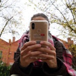 Una joven utiliza un móvil en las cercanías de un Instituto de Valladolid
