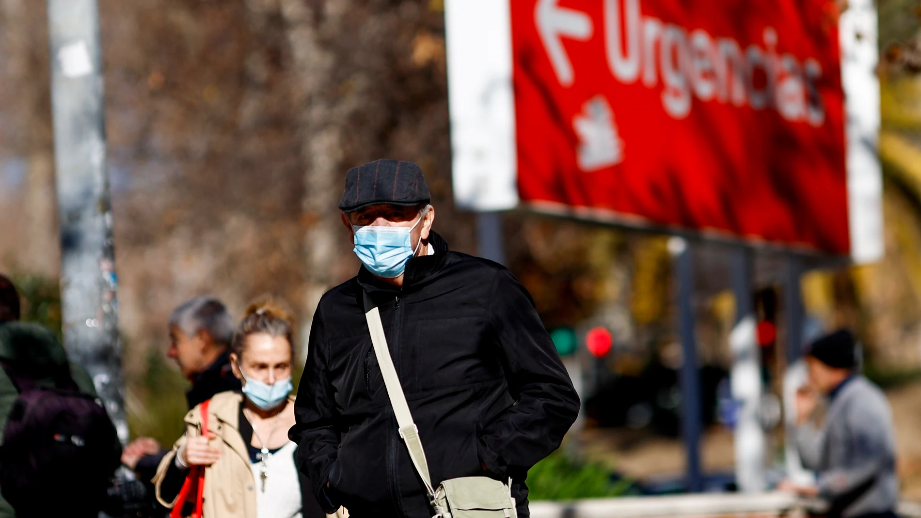 MADRID, 08/01/2024.- Personas con mascarillas caminan en el entorno de un centro sanitario en Madrid este lunes, día en el que el Ministerio de Sanidad ha pedido a las comunidades que implanten el uso obligatorio de la mascarilla en centros sanitarios y sociosanitarios, una medida que se aplicaría de forma transitoria mientras dure el pico epidémico de la gripe y otros virus respiratorios, y que ya han decretado Cataluña, la Comunidad Valencia y Murcia. EFE/ Rodrigo Jiménez