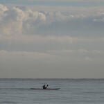 Una persona en la playa de la Malvarrosa hoy, con el cielo nuboso de fondo.