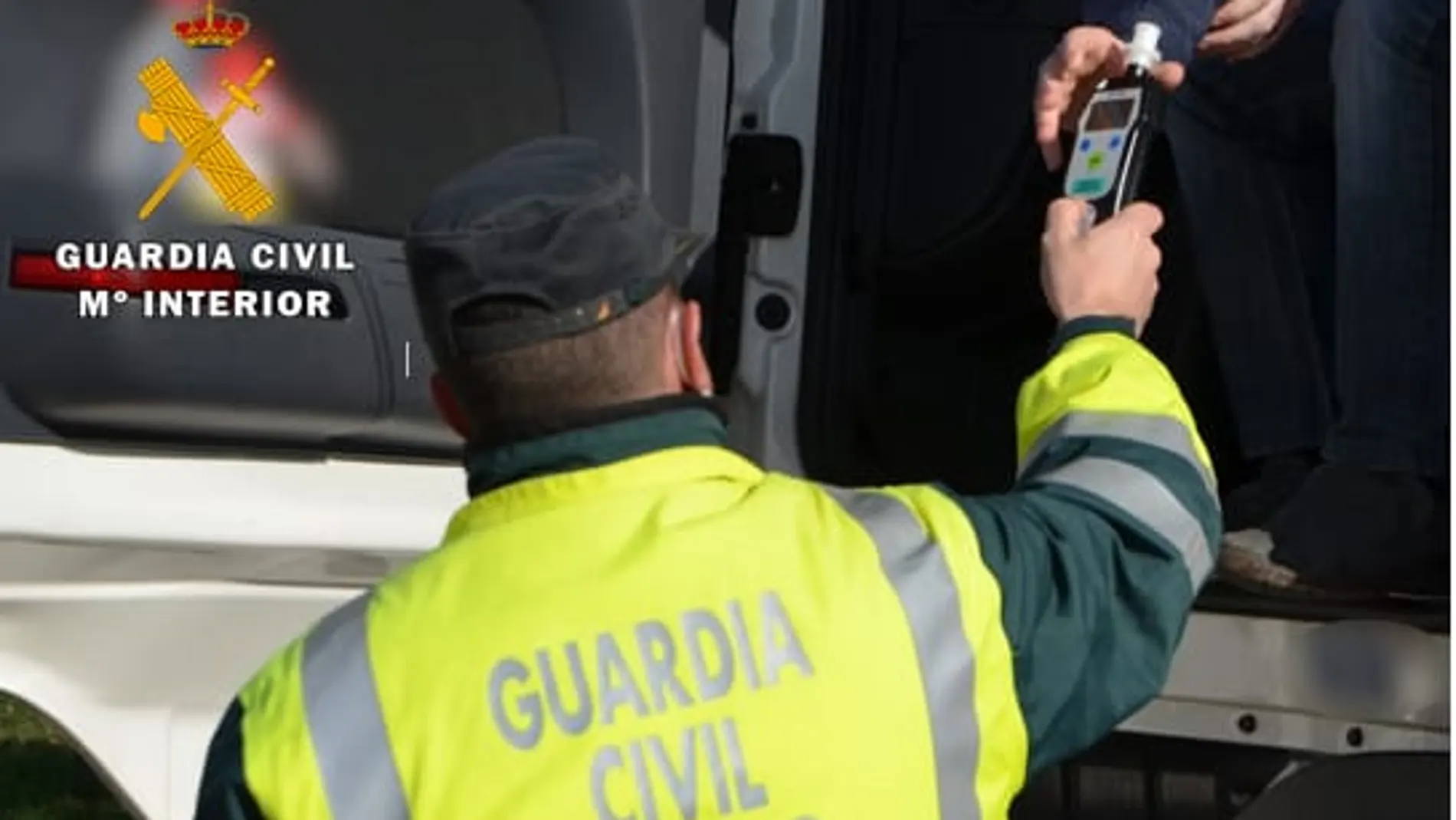 Un agente de la Guardia Civil realiza una prueba de control de alcoholemia a un conductor
