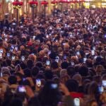 FILED - 30 November 2021, Spain, Malaga: People hold their mobile phones ahead of the start of Christmas lighting in Marques de Larios street. As every year, the Christmas lights welcomes Christmas season in downtown city. Despite the rise of infections in the city, thousands of people have gathered to watch the Christmas lights show. Photo: -/ZUMA Press Wire/dpa 30/11/2021 ONLY FOR USE IN SPAIN