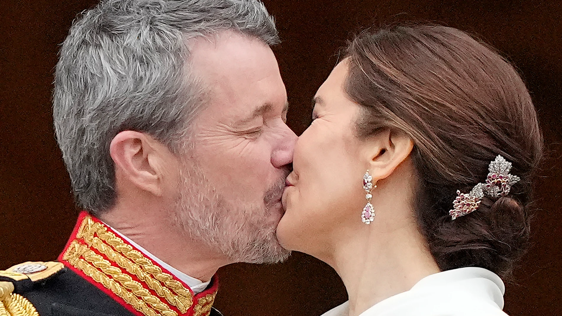 Denmark's King Frederik X kisses his wife Denmark's Queen Mary on the balcony of Christiansborg Palace in Copenhagen, Denmark, Sunday, Jan. 14, 2024. Queen Margrethe II has become Denmark's first monarch to abdicate in nearly 900 years when she handed over the throne to her son, who has become King Frederik X. (AP Photo/Martin Meissner)