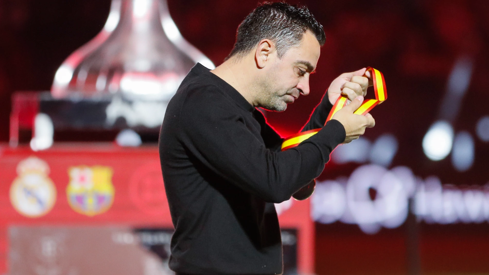 RIAD (ARABIA SAUDÍ), 14/01/2024.- El técnico del FC Barcelona Xavi Hernández se quita la medalla de segundo clasificado tras perder su equipo la final de la Supercopa de España que Real Madrid y FC Barcelona han disputado este domingo en el estadio Al Awwal Park de Riad, en Arabia Saudí. EFE/Juan Carlos Cárdenas