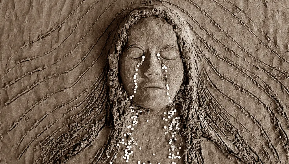 Dibujos en la arena con los pellets limpiados de las playas, una sirena