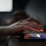 Un hombre intenta apagar la alarma del móvil 