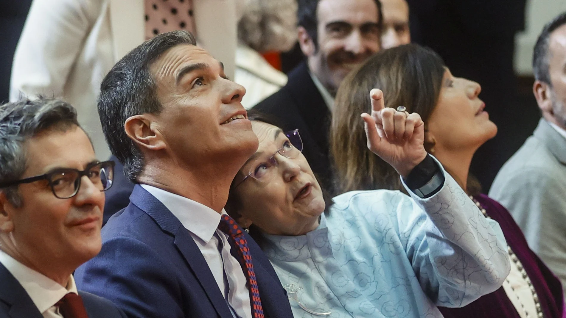 El presidente del Gobierno, Pedro Sánchez, atiende unas indicaciones de la presidenta de la Comisión Nacional de los Mercados y la Competencia, Cani Fernández, en presencia del ministro de la Presidencia, Justicia y Relaciones con las Cortes, Félix Bolaños