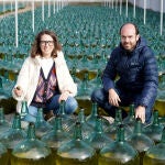 La responsable de Comunicación de Bodegas Hijos de Alberto Gutiérrez, Ángeles Jiménez, y el export manager, Mariano de Juan, junto a las damajuanas de los 'vinos generosos', en Serrada (Valladolid)
