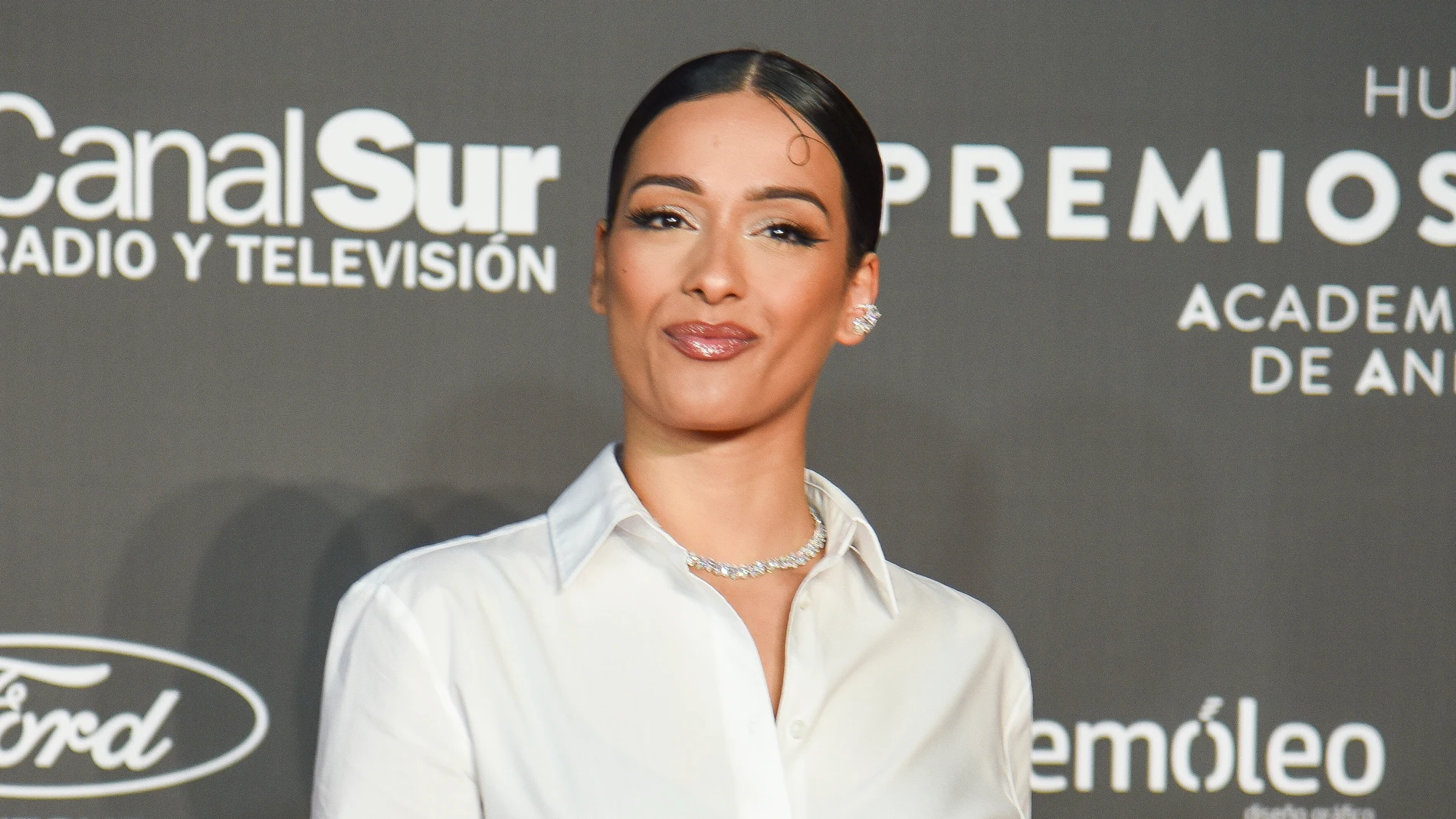 Chanel Terrero en los Premios Carmen 2024 con vestido con abertura y camisa blanca.