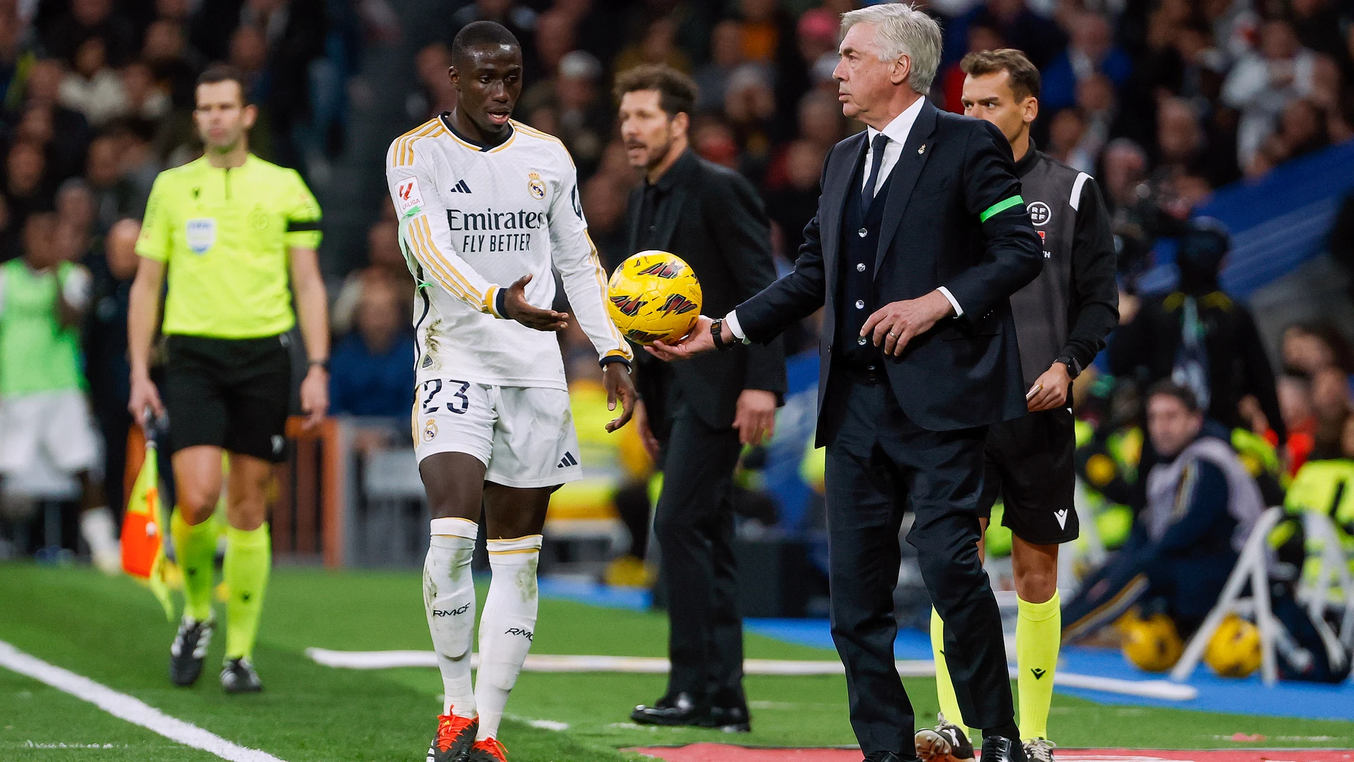 MADRID, 04/02/2024.- El entrenador del Real Madrid, Carlo Ancelotti (d), entrega el balón a Ferland Mendy (d), durante el partido de LaLiga de fútbol que Real Madrid y Atlético de Madrid han disputado este domingo en el estadio Santigo Bernabéu. EFE/Juanjo Martín