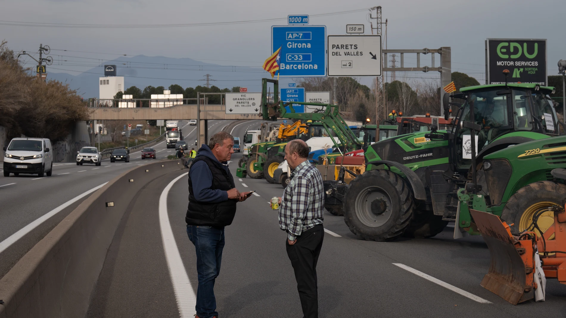 Varias personas entre los tractores que han cortado la carretera C-17, sentido sur, a la altura de Parets del Vallès, a 6 de febrero de 2024, en Parets del Vallès, Barcelona, Catalunya (España). Agricultores y ganaderos de toda España han sacado sus tractores a las carreteras desde esta madrugada para pedir mejoras en el sector, entre ellas exigir ayudas para afrontar las sequías que sufre el campo. Además, protestan contra las políticas europeas y su falta de rentabilidad. 06 FEBRERO 2024;C...