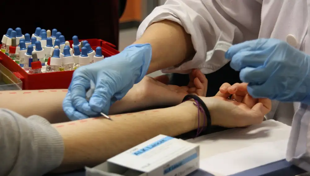 Un sanitario realiza una prueba de alergia a una paciente