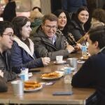 El presidente del PP; Alberto Núñez Feijóo (4i), se reúne con jóvenes en la churrería "La Modernita" en Lugo este viernes.
