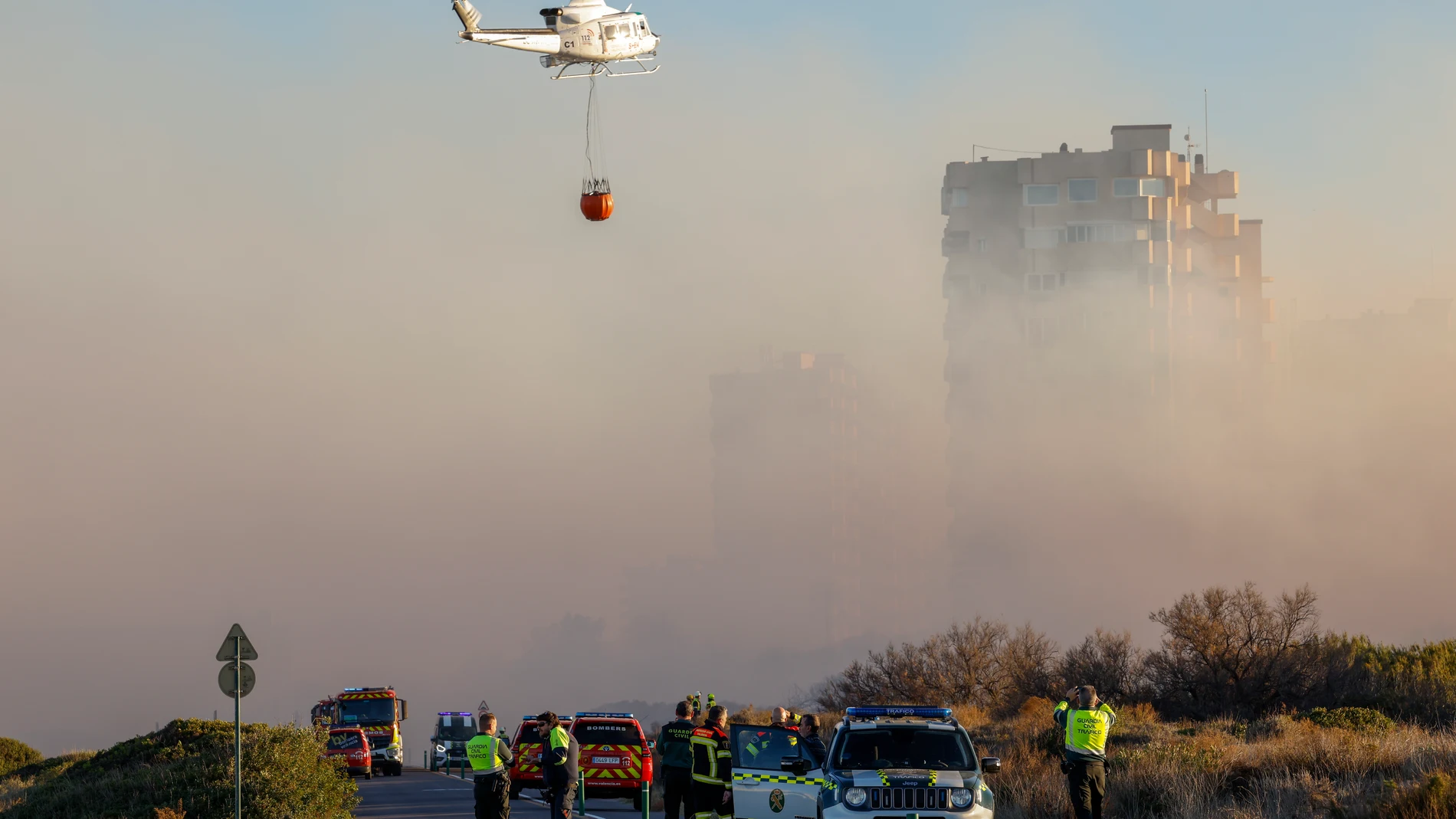 GRAFCVA8307. VALENCIA, 12/02/2024.- Un helicóptero trabaja en las labores de extinción del incendio forestal declarado a primera hora de la tarde de este lunes en El Saler, en València, que ha obligado a desalojar un edificio próximo al antiguo hotel Sidi Saler y ha movilizado medios de extinción terrestres, un aéreo y asistencia médica para asistir a un afectado por inhalación de humo. EFE/Ana Escobar