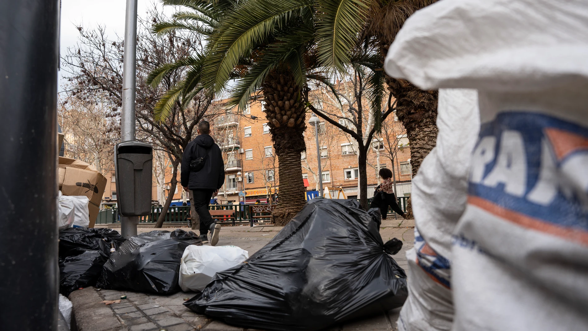 Basura fuera de los cubos en Usera