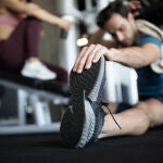 Un hombre realiza estiramientos en un gimnasio