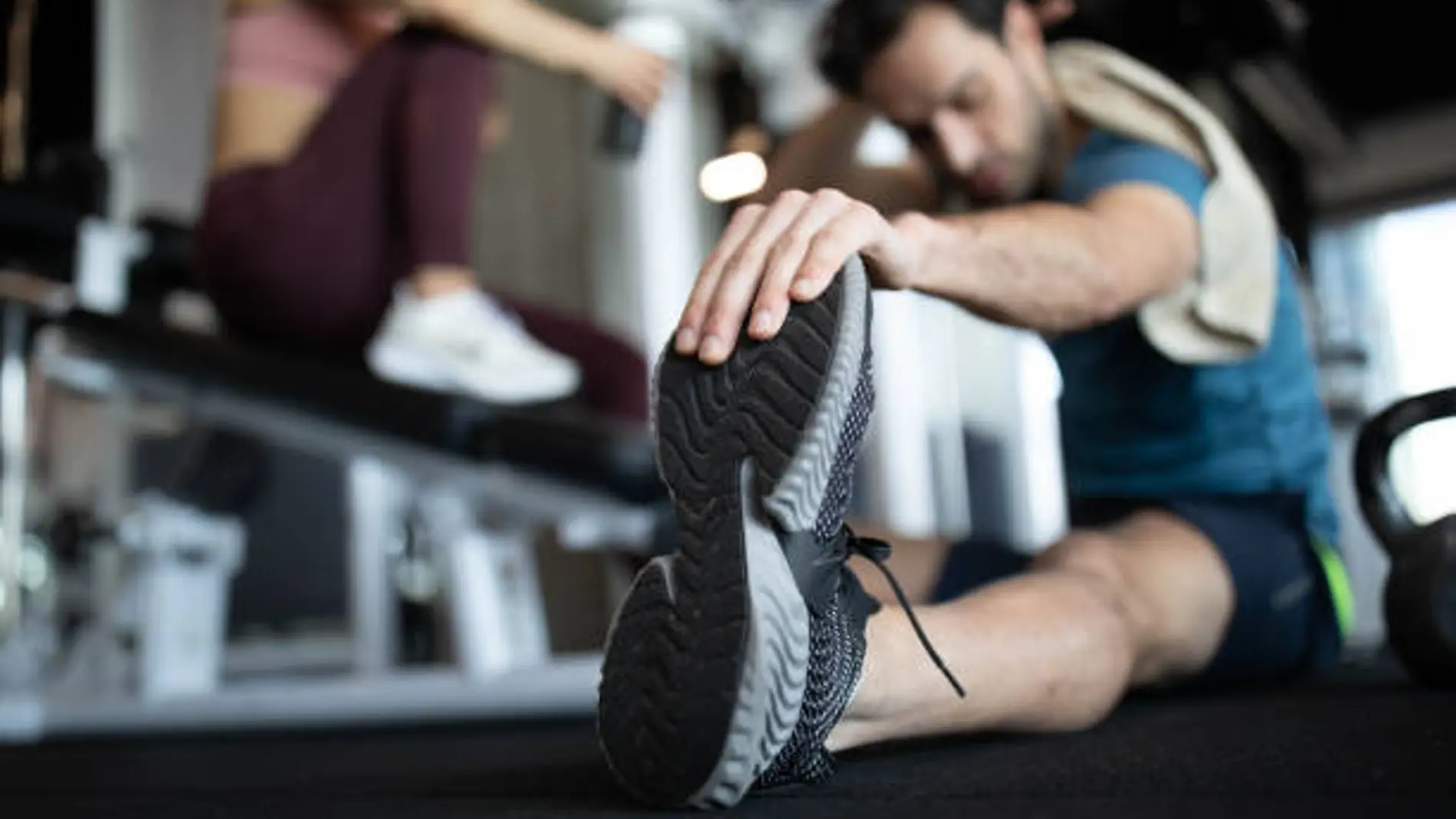 Un hombre realiza estiramientos en un gimnasio