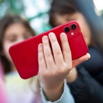 Niños con el teléfono móvil a la puertas de un colegio. 