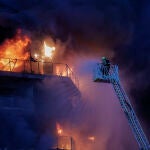 Los bomberos intentan rescatar a vecinos atrapados por el fuego desde los balcones