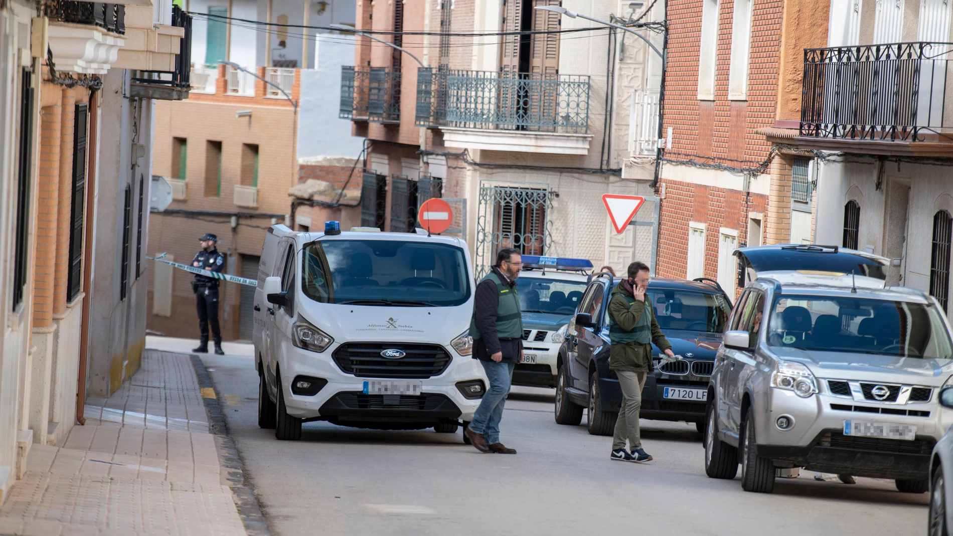 Dos agentes de la Guardia Civil y un vehículo funerario de recogida en las inmediaciones del lugar donde se ha producido el asesinato a una mujer, a 23 de febrero de 2024, en Aldea del Rey, Ciudad Real