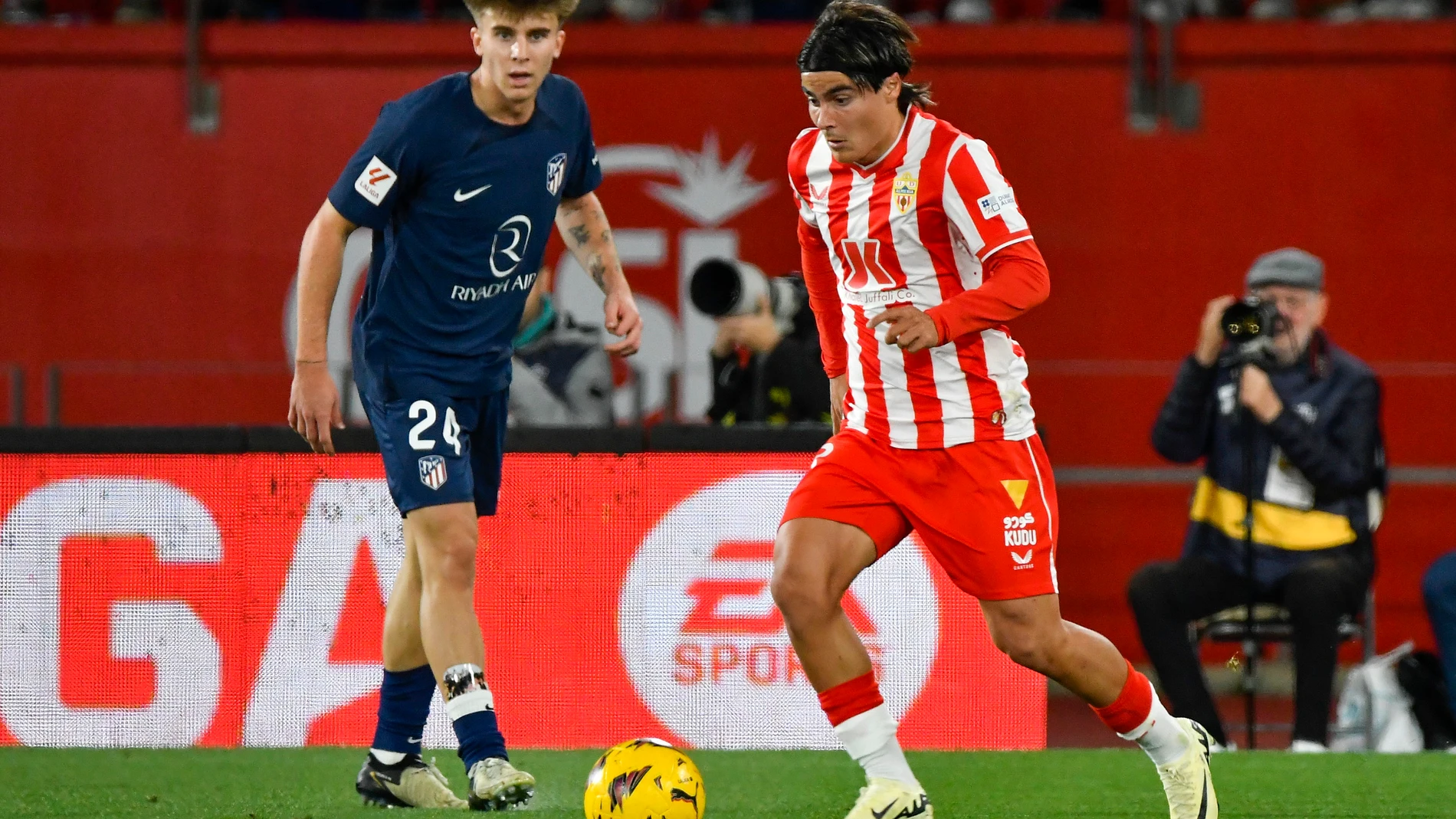 ALMERÍA 24/02/2024.- El centrocampista del Almería Luka Romero (d) controla el balón ante el centrocampista del Atlético de Madrid Pablo Barrio durante el partido de LaLiga entre la Ud Almería y el Atlético de Madrid celebrado este sábado en el Power Horse Stadium de Almería. EFE / Carlos Barba