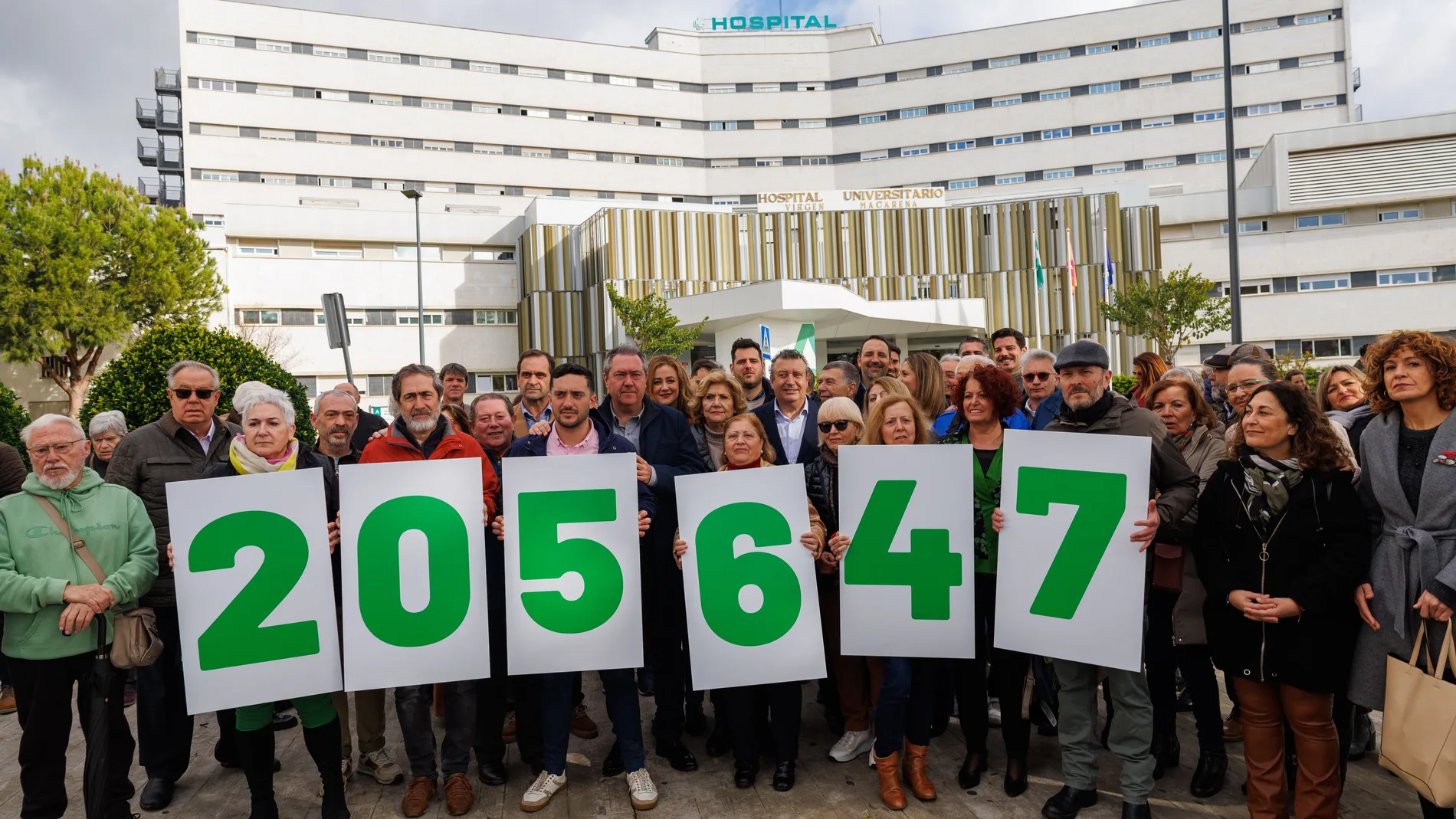 Un grupo de militantes socialistas portan carteles con la cifra 205.674, que corresponde a los sevillanos en listas de espera